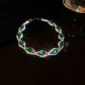 Close-up view of an elegant emerald green crystal bracelet with sparkling rhinestones.