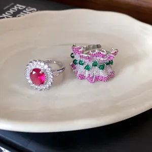 Detailed view of luxury Korean style zircon rings with red oval stone and pink ruffled design