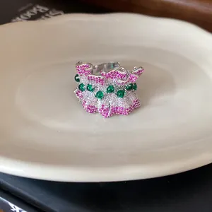 Detail showing the intricate ruffled design and pavé pink zircon stones on an open ring.