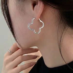 Elegant minimalist silver needle geometric clover hoop earrings worn by female model