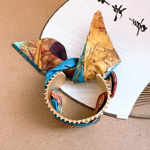 Close-up of ethnic style acrylic bracelet with artistic oil painting fabric bow detail