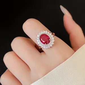 Close-up of elegant silver ring with large oval red zircon and clear stone halo