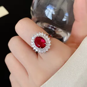 Detailed view of an elegant red oval zircon ring featuring a sparkling white halo