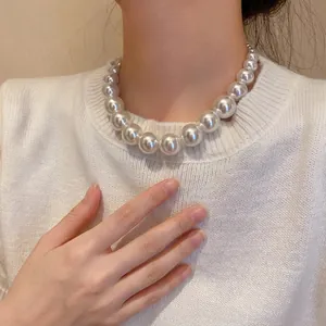 Elegant white graduated pearl necklace with vintage baroque design on female model