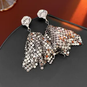 Detailed macro view of silver mesh chainmail earrings with textured studs