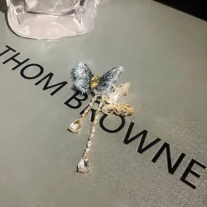 Broche papillon à pampilles en zircon avec ailes en tissu bleu et finition dorée