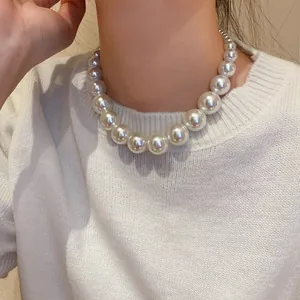Close-up view of elegant vintage gradient pearl necklace worn with a white sweater.