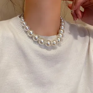 Close-up of graduated pearl necklace on model, showing elegant vintage baroque style.
