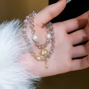 Close-up detail of an elegant double-layered bracelet with cat's eye beads and pearls