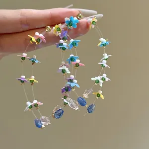Prachtig detail van handgemaakte kleurrijke bloemen oorringen met pailletten en kralen
