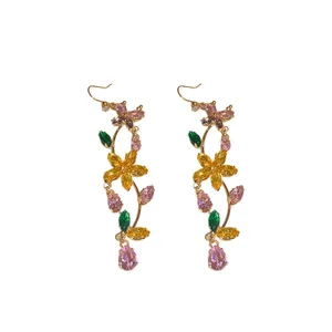 Sparkling colorful cubic zirconia butterfly and flower dangle earrings on white background