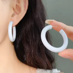Detailed view of minimalist glossy white acrylic C-shaped hoop earrings for women