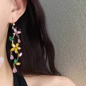 Close-up of sparkling multi-color zircon butterfly and flower tassel earrings on a model