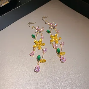 Close-up of sparkling flower and butterfly dangle earrings with colorful zirconia.
