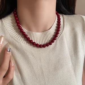 Detailaufnahme einer Vintage-Halskette mit roten Ankara-Glasperlen am Hals des Modells