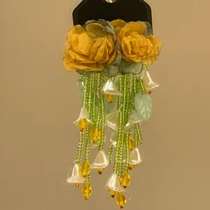 Handmade yellow flower earrings with green seed bead tassels and shell lily of the valley