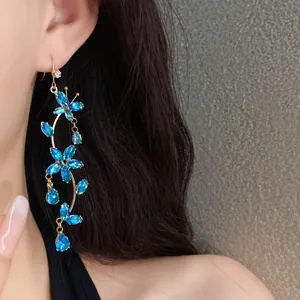 Detail shot showing sparkling blue zircon butterfly flower tassel hook earrings.