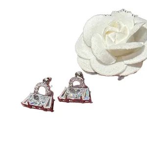 Elegant handbag-shaped stud earrings with sparkling cubic zirconia on a white background