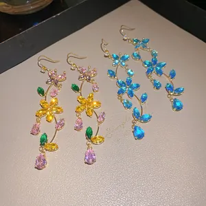 Detailed close-up of sparkling flower and butterfly cubic zirconia tassel earrings.
