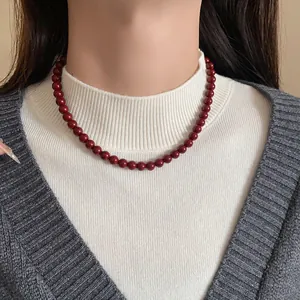 Nahaufnahme einer Ankara roten Glasperlenkette, getragen von einem weiblichen Modell