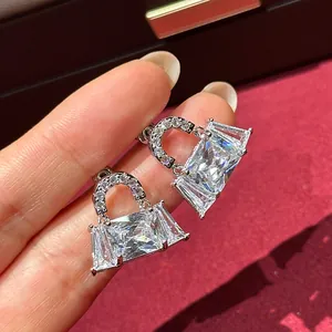Close-up of elegant silver handbag stud earrings featuring brilliant cubic zirconia inlays.