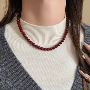 Detailansicht der Ancora-Halskette mit roten Glasperlen für einen eleganten Retro-Stil.