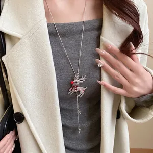 Fashionable rhinestone reindeer pendant necklace shown worn over a cream winter coat
