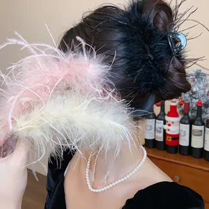 Detail of elegant feather hair claw clip in black, pink, and white for bun hairstyles.