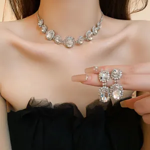 Detailed view of elegant silver oval rhinestone necklace and earring set on model