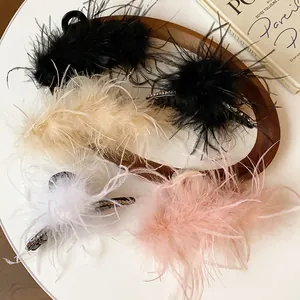Detailed view of various colors of French style feather hair claw clips with rhinestone accents
