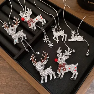 Detailed macro shot of rhinestone reindeer Christmas pendant necklaces in a jewelry tray