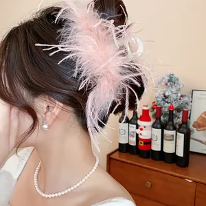 Detailed view of elegant pink feather hair claw clip for a French bun hairstyle.
