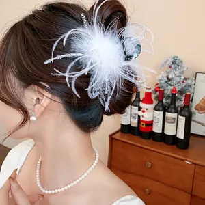 Detailed shot of a white ostrich feather hair claw clip used in an elegant hair updo
