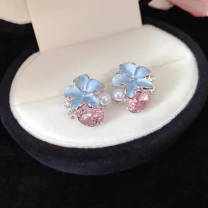 Macro view of French style light luxury flower stud earrings with pink crystal and pearl