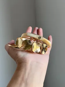 Nahaufnahme der goldenen gehämmerten Metalltexturen dieses stilvollen vierteiligen Armreifensets