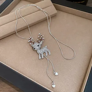 Close-up of sparkling rhinestone reindeer pendant on silver snake chain necklace