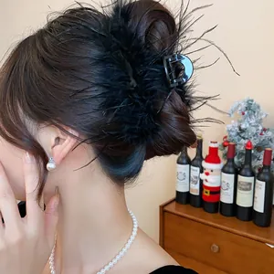 Elegant French style black feather hair claw clip shown in a sophisticated hair updo style