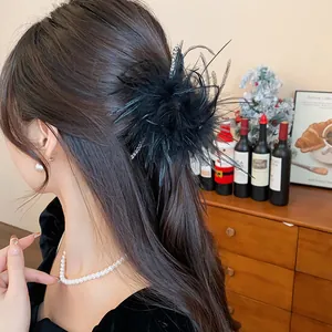 Close-up detail of an elegant French black feather hair claw clip with rhinestones.