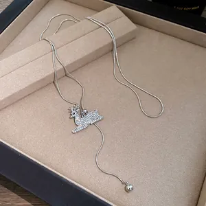 Detailed close-up of a silver-tone snake chain necklace with a diamond deer pendant