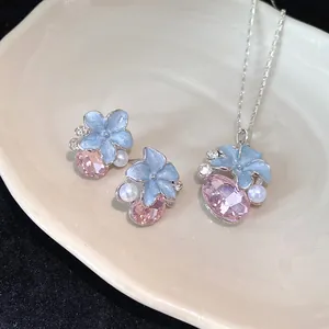 Detailed macro view of blue enamel flower and pink crystal jewelry set