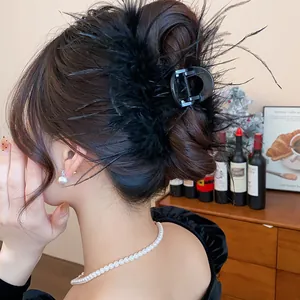 Elegant black feather hair claw clip shown in detail for French style hair bun styling
