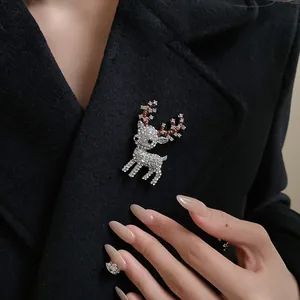 Detail of sparkling rhinestone reindeer brooch on a black wool coat