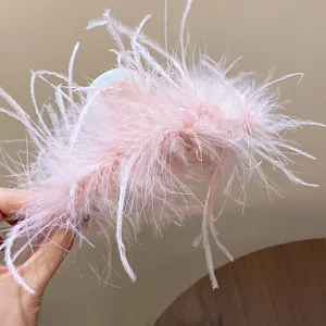 Close-up of a elegant light pink feather hair claw clip for French style updos