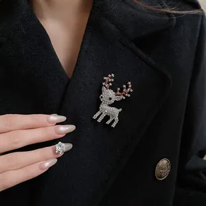 Detailed view of a sparkling rhinestone deer brooch pinned on a black wool coat