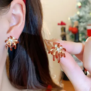 Close-up of 18k gold plated firework earrings with red enamel and zircons