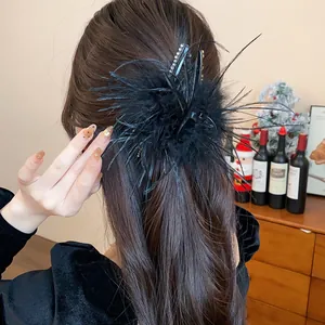 Elegant black feather hair claw clip with rhinestones shown on a woman's hair back view