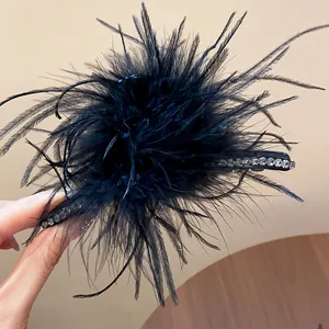 Detailed view of a black feather hair clip with sparkling rhinestone accents