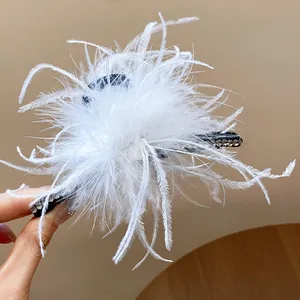 Close-up view of a French style white feather hair claw clip with rhinestone details
