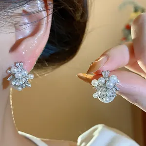 Detailed view of firework cluster pearl earrings with zircons and silver needle.