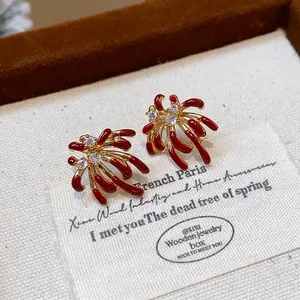 Macro detail of firework stud earrings with red enamel and brilliant zircon stones